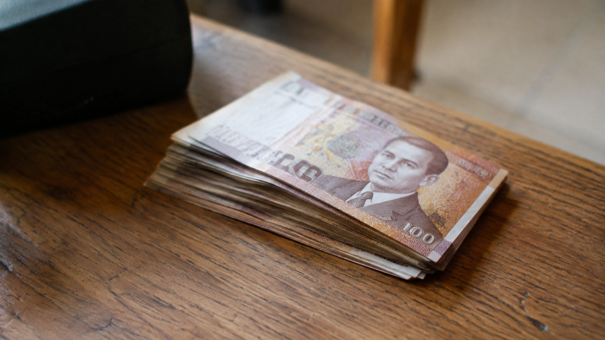 Billets de dirhams empiles sur une table en bois