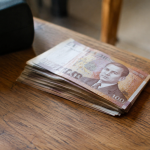 Billets de dirhams empiles sur une table en bois