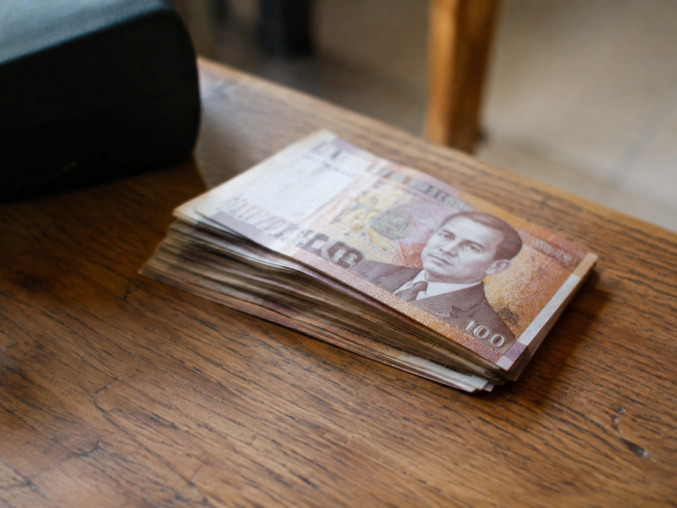 Billets de dirhams empiles sur une table en bois