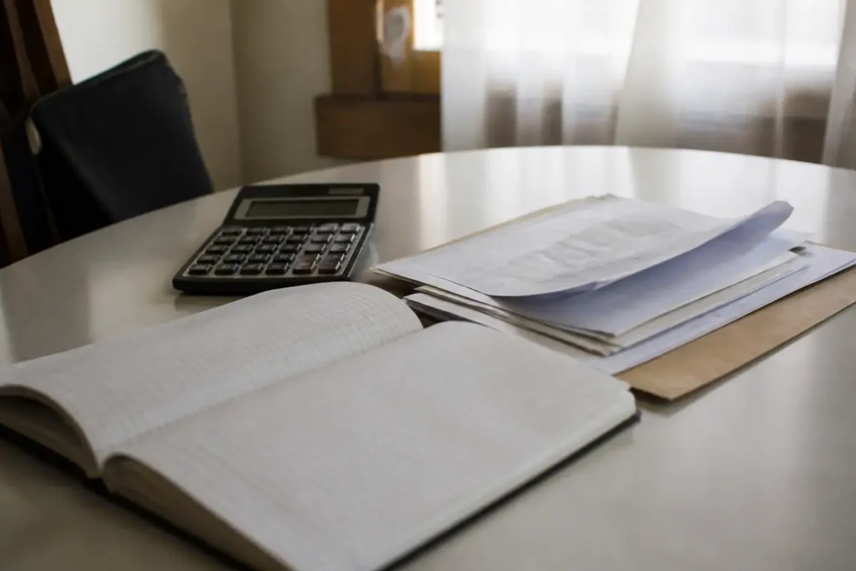 Carnet ouvert avec calculatrice et devis sur un bureau