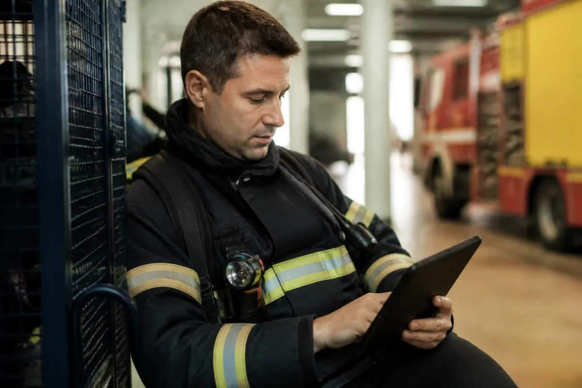 Pompier en tenue lisant une grille tarifaire sur tablette