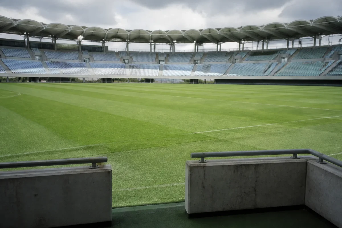 Stade de football vide avec tribunes et pelouse verte